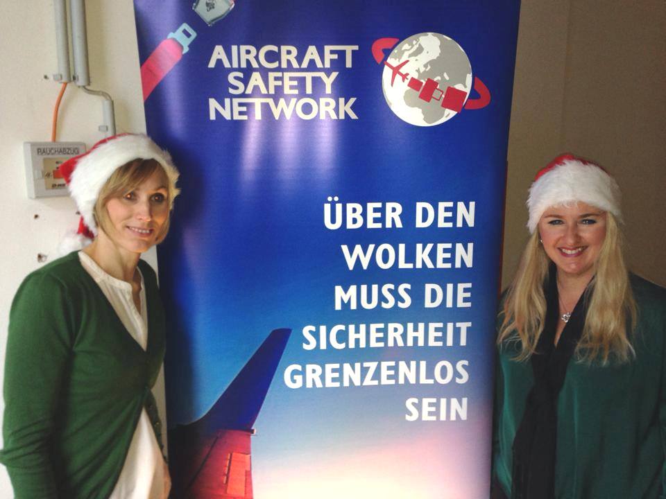 Das Bild zeigt Barbara Pencik und Barbara Letuha mit Weihnachtsmütze vor dem Werbebanner von ASN.